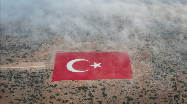 Mersin'in Mut ilçesinde bulunan ve yaklaşık 22 dönümlük dev bir arazi üzerine titizlikle işlenen Türk bayrağı, sabah saatlerinde etkili olan yoğun sis ile birlikte adeta masalsı bir manzara sundu.